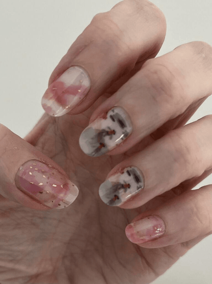 Close-up hand showing koi fish nail wraps with watercolour design and gold accents