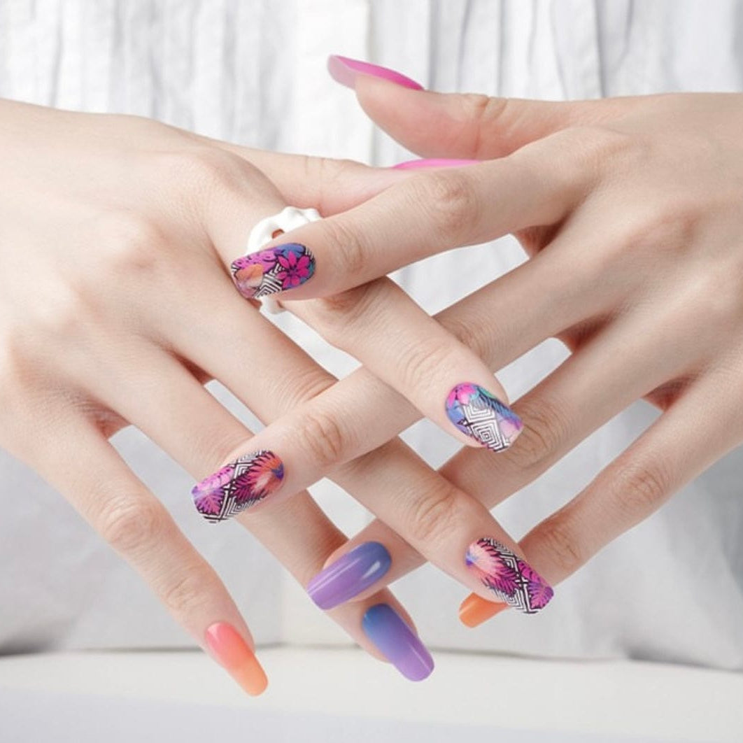 Hands showing tropical geometric nail art with colourful patterned nail wraps and solid colours