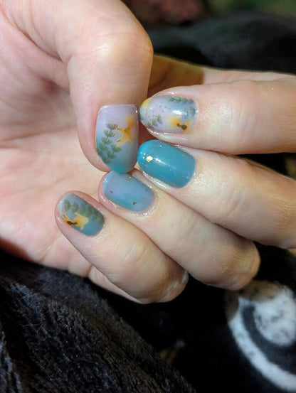 Teal and grey nail wraps with gold cranes and pine branch design