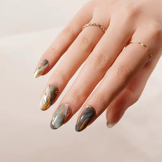 Green sage marble nail wraps with gold veining on hand showing almond shape manicure