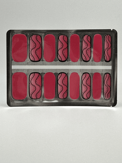 Pink nail wraps with black swirl patterns displayed in application sheet packaging