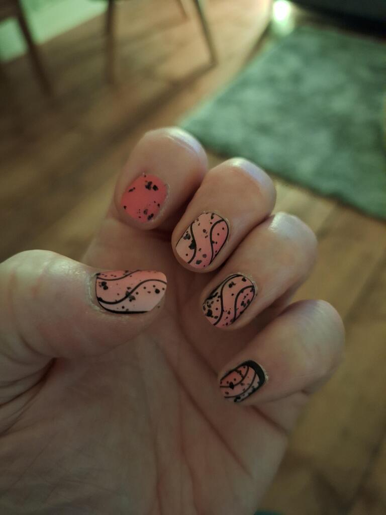 Pink nail wraps with black speckles and abstract swirl line design