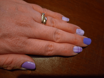 Hand wearing purple lavender nail wraps with plaid pattern manicure design