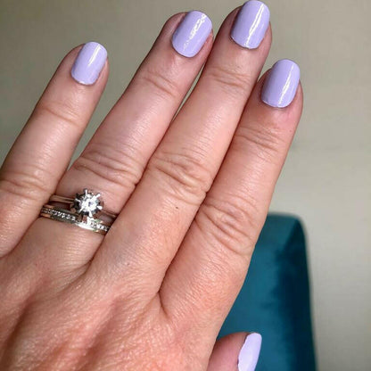 Hand wearing soft lavender nail wraps with glossy finish and diamond ring showing purple nails