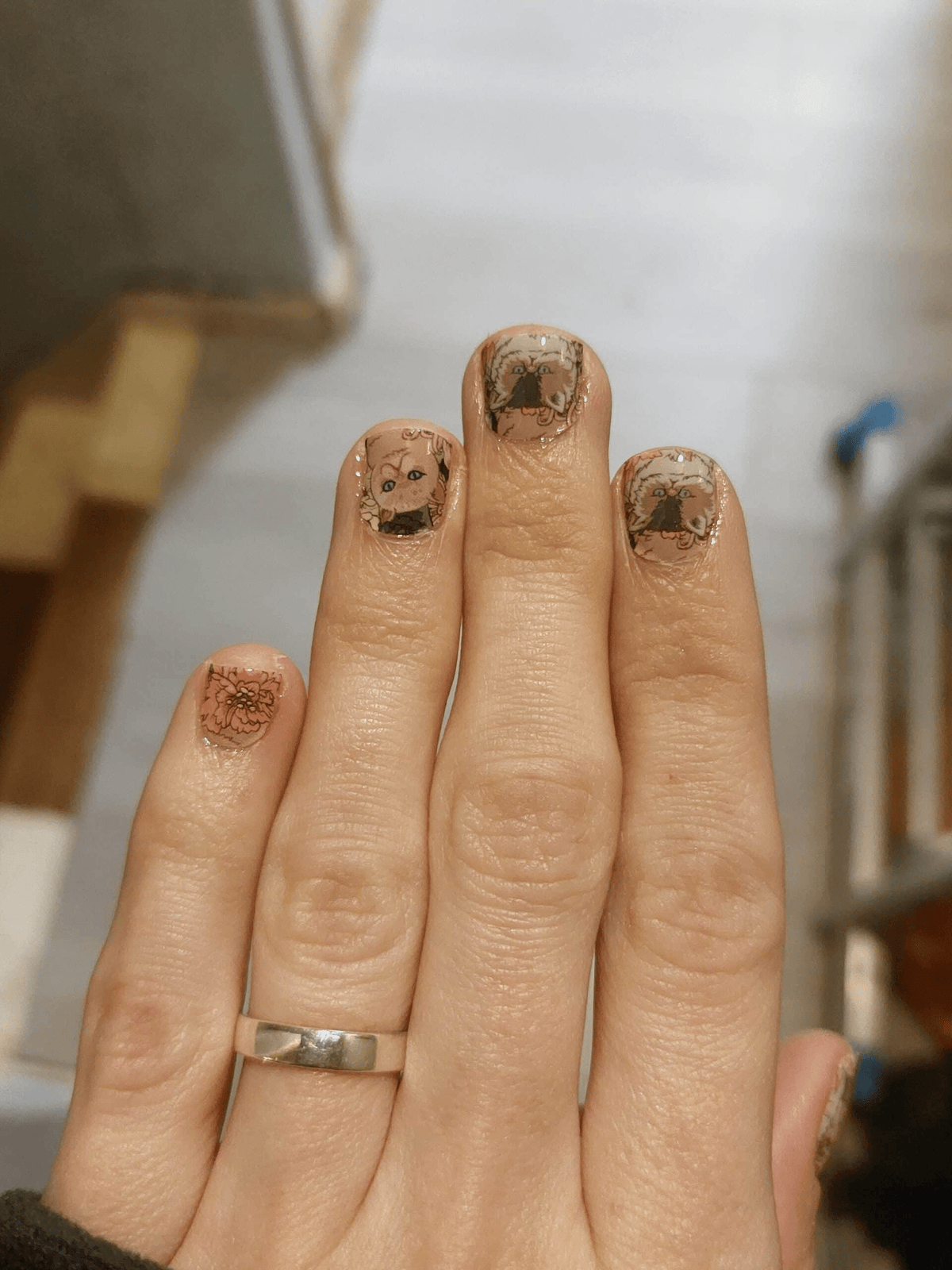 Cat themed nail wraps on fingers showing vintage botanical illustrations