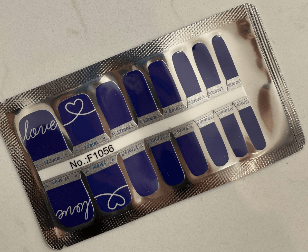Royal blue pedicure nail wraps in packaging showing love script design for toes