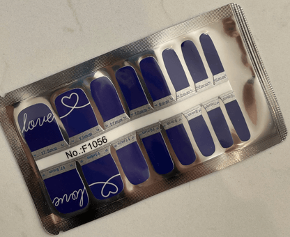 Royal blue pedicure nail wraps in packaging showing love script design for toes