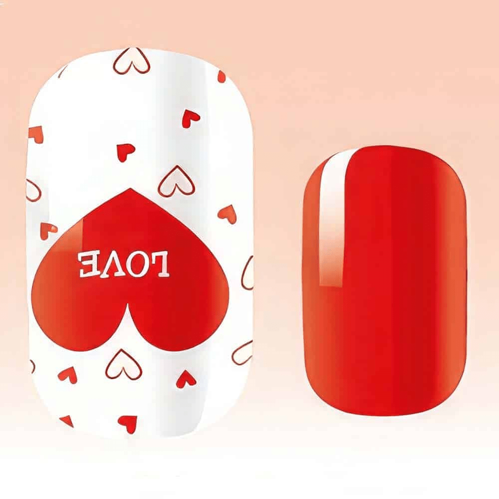 Close-up of red glossy nail wrap with white heart pattern and love text detail