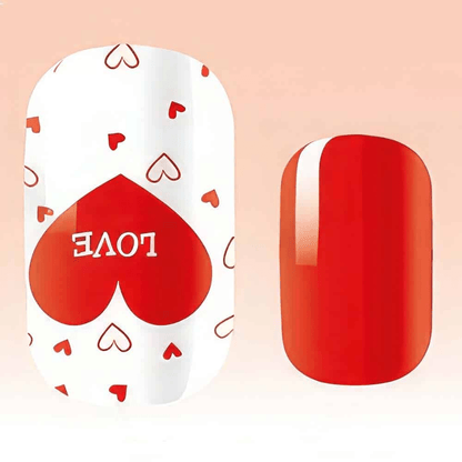 Close-up of red glossy nail wrap with white heart pattern and love text detail