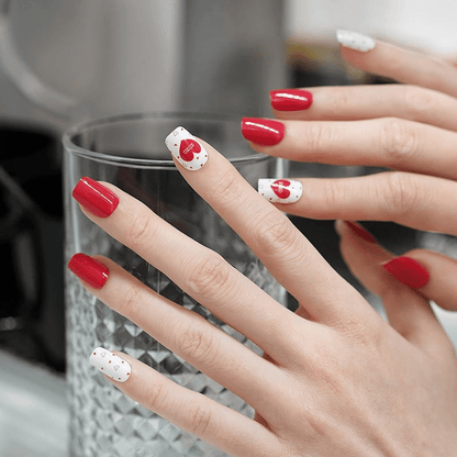 Valentine's Day nail wraps on hands with red glossy and white heart XOXO design