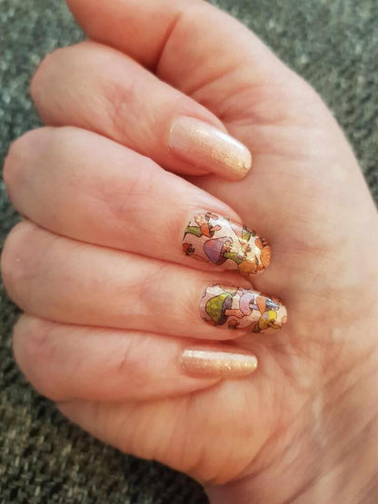 Botanical nail art wraps featuring colourful mushroom illustrations on natural nails