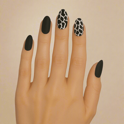 Black and white animal print nail wraps on hand showing giraffe pattern manicure