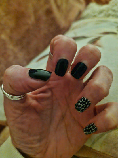 Glossy black nail wraps with two accent nails in green-black snakeskin print