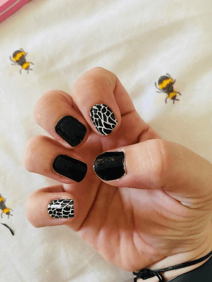 Glossy black nail wraps with black-and-white crackled animal print accent nails
