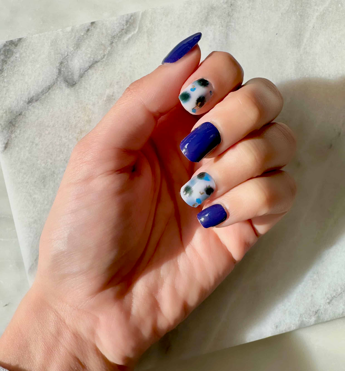 Blue abstract terrazzo nail art wraps displayed on hand with sheer contemporary pattern design