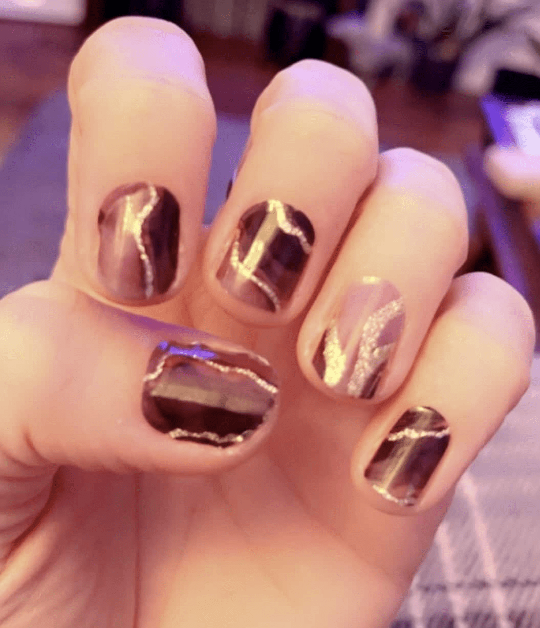 Glossy brown nail wraps with metallic gold crackled marble-effect veining, high-shine finish