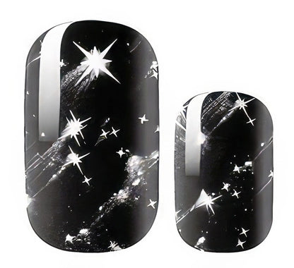 Black celestial nail wraps with silver stars and cosmic sparkle design