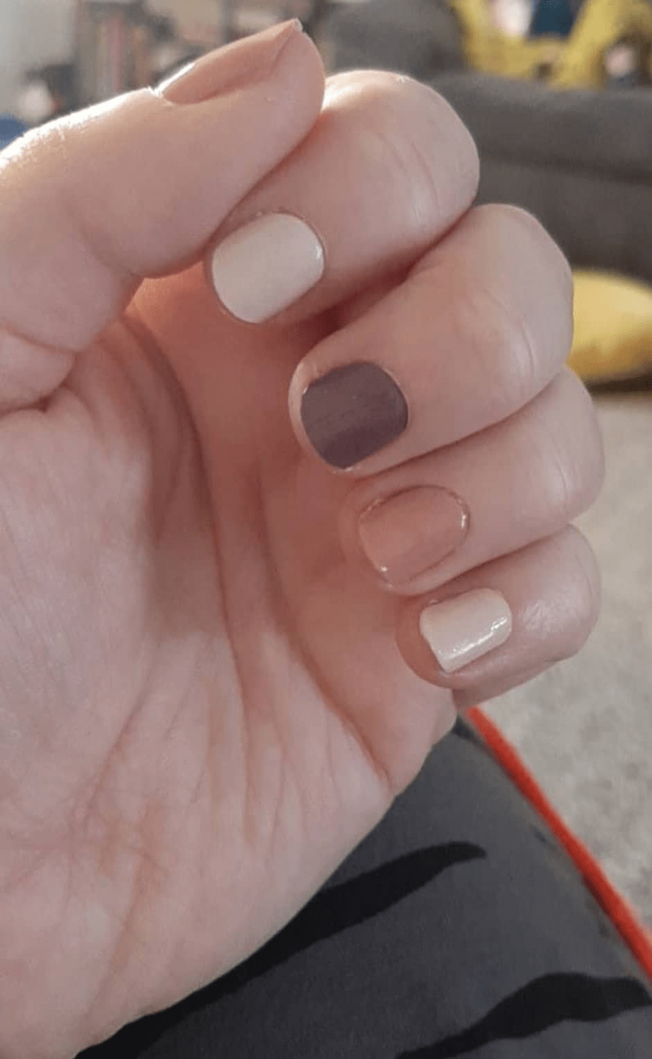 Close-up of short nails with Holy Classics nail wraps in mocha brown, cream and nude shades, glossy finish.