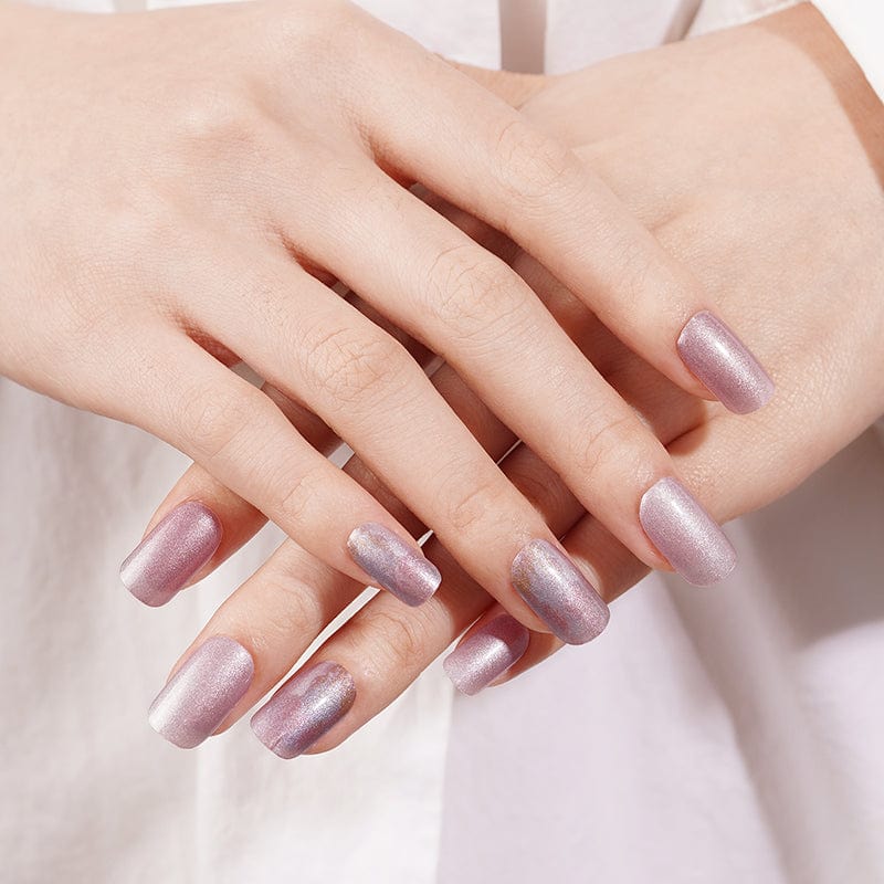 Hands displaying pink pearl nail wraps with soft shimmer effect manicure