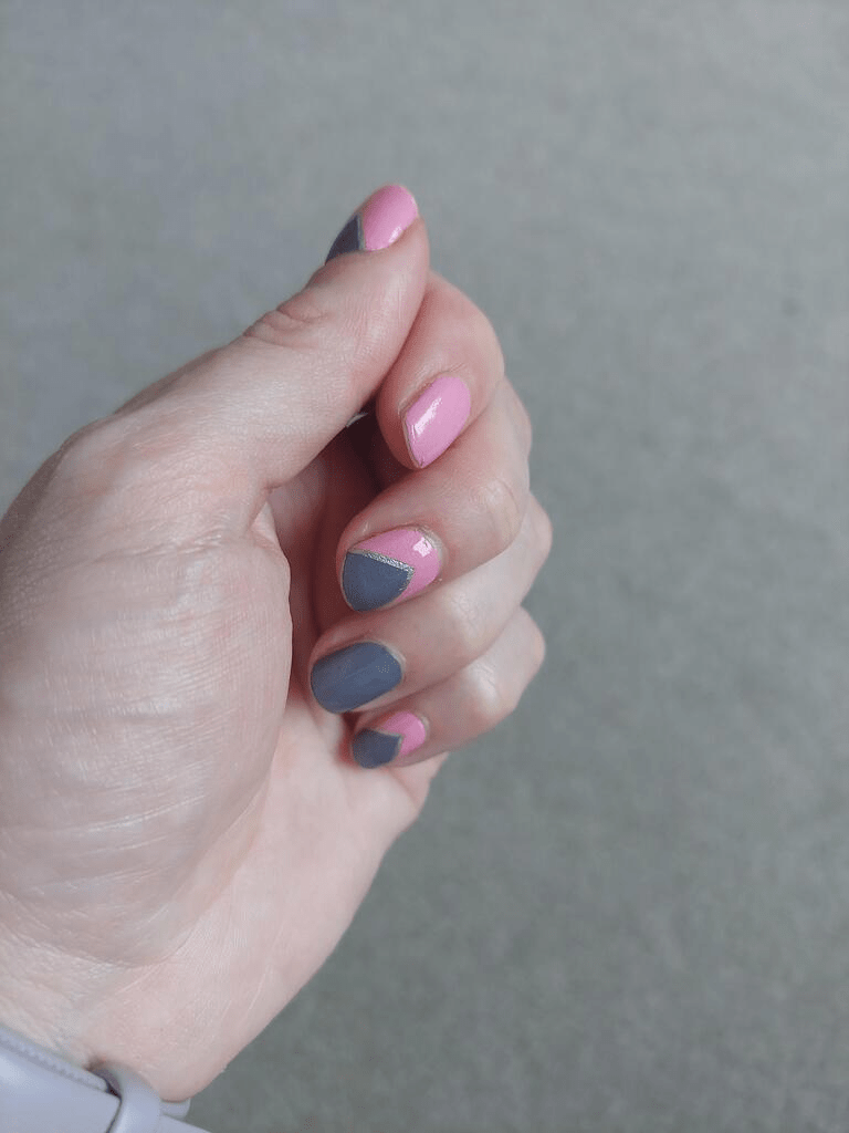 Pink and grey geometric nail wraps on hand showing modern abstract nail art design