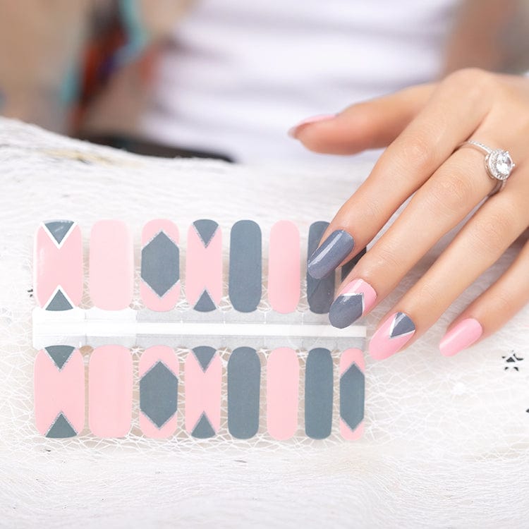 Hand wearing pink and grey geometric nail wraps with contemporary architectural pattern design