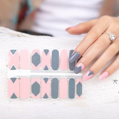 Hand wearing pink and grey geometric nail wraps with contemporary architectural pattern design