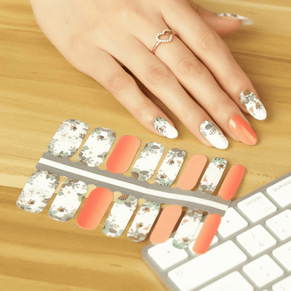 Floral bee nail wraps on hand with peach and white botanical design for at-home manicure