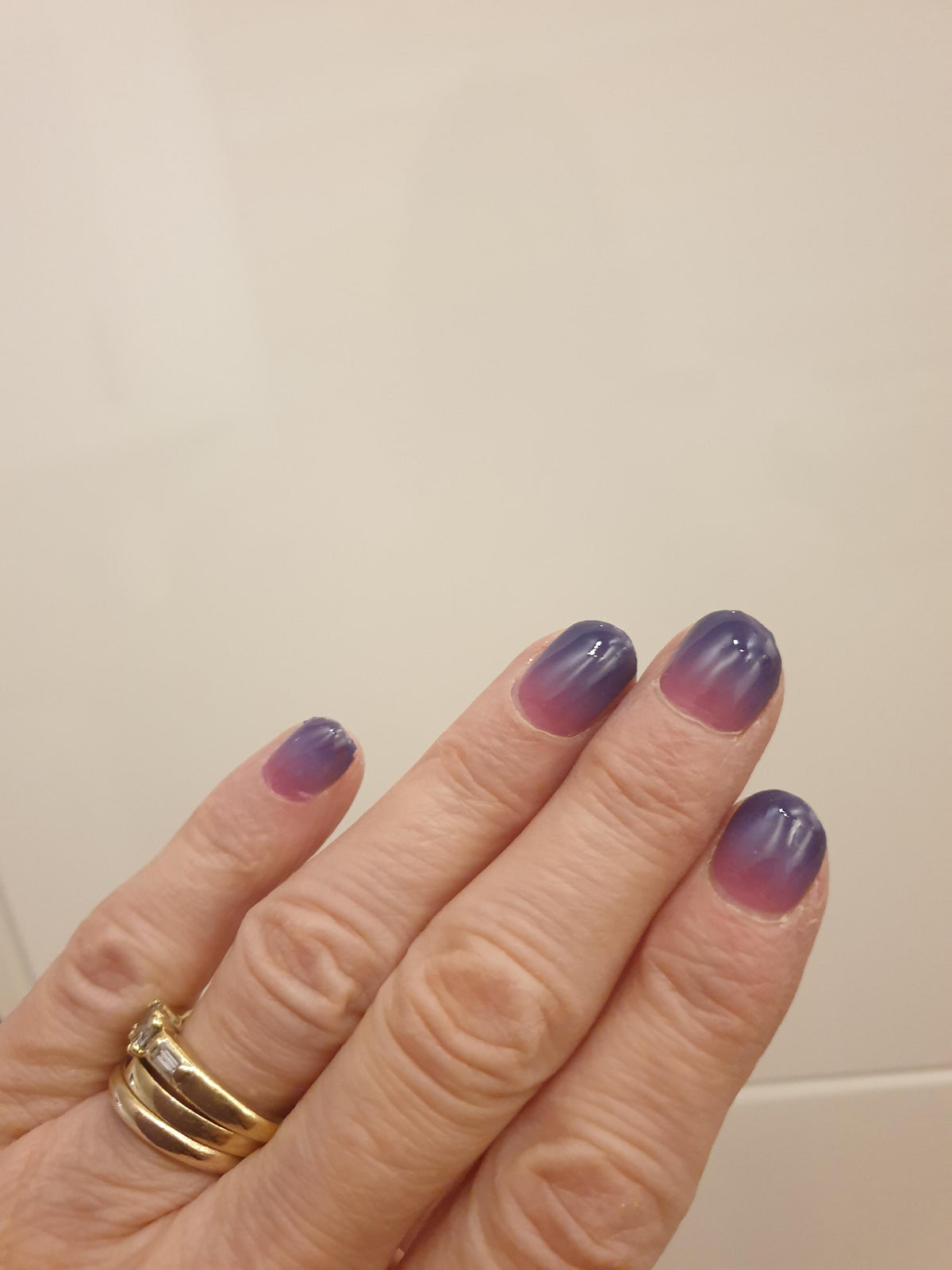 Twilight gradient nail wraps on hand displaying purple to pink ombre at-home manicure