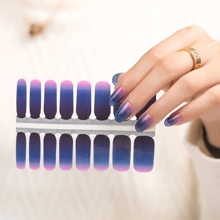 Blue-to-pink ombré nail wraps with sheer, shimmering finish on shaped sheet