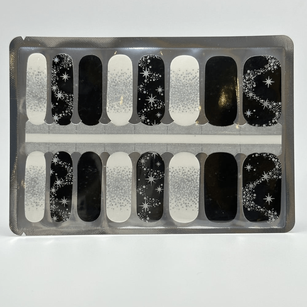 Black and white nail wraps with silver glitter, star accents and constellation motifs
