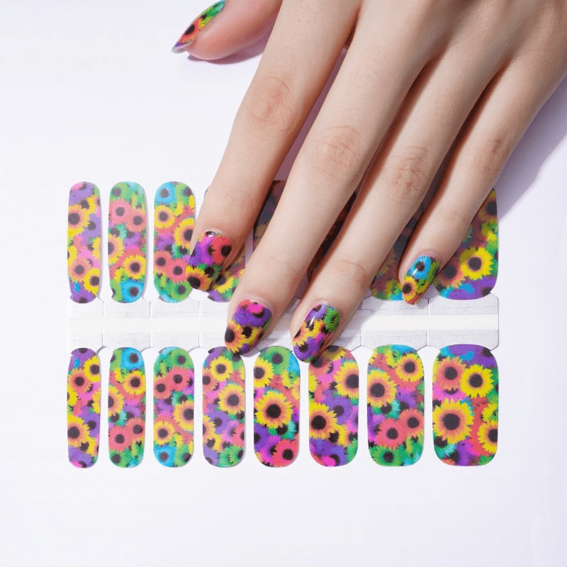 Hand wearing colourful sunflower nail wraps with vibrant floral art design for at-home manicure