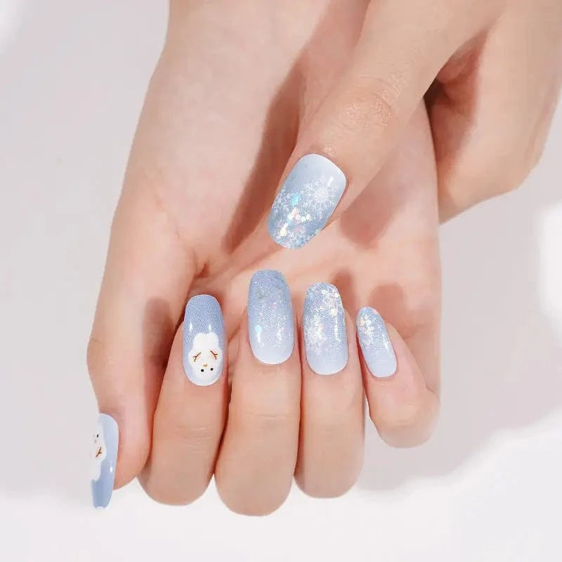 Festive blue gradient nail wraps with sparkly snowflakes and adorable snowman accent