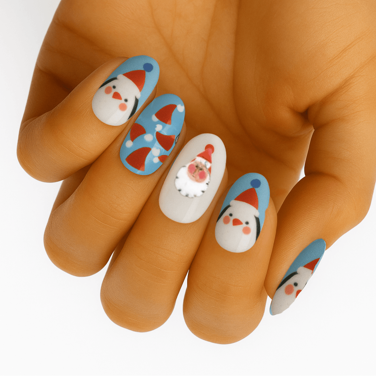 Cute penguin nail art on hand featuring blue and white cartoon characters, festive Christmas nail wraps