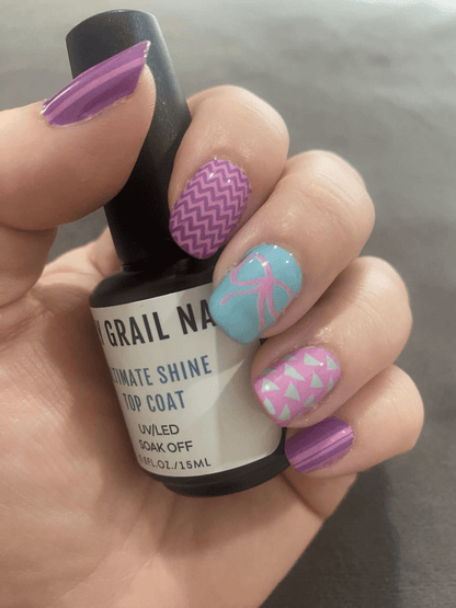Hand displaying retro 80s nail wraps with purple chevron turquoise palm pink geometric patterns