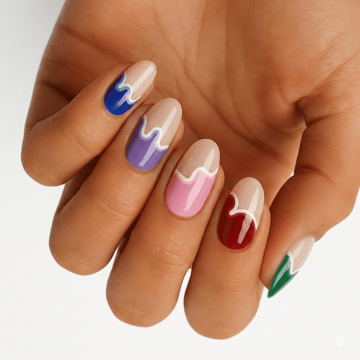 Multicoloured paint drip nail wraps on hand showing blue purple pink red green artistic design