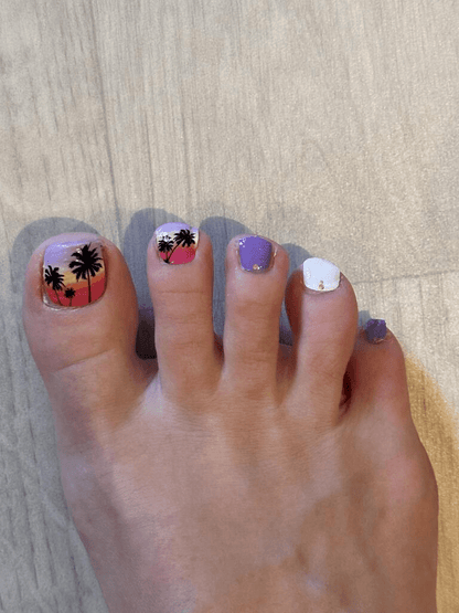 Purple pink sunset nail wraps applied on toes showing tropical palm tree design