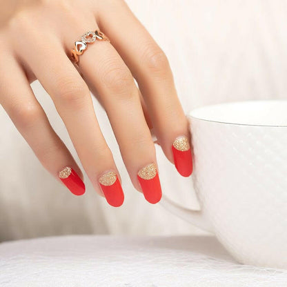 Elegant red and gold glitter nail art wraps showing reverse French manicure design on hand
