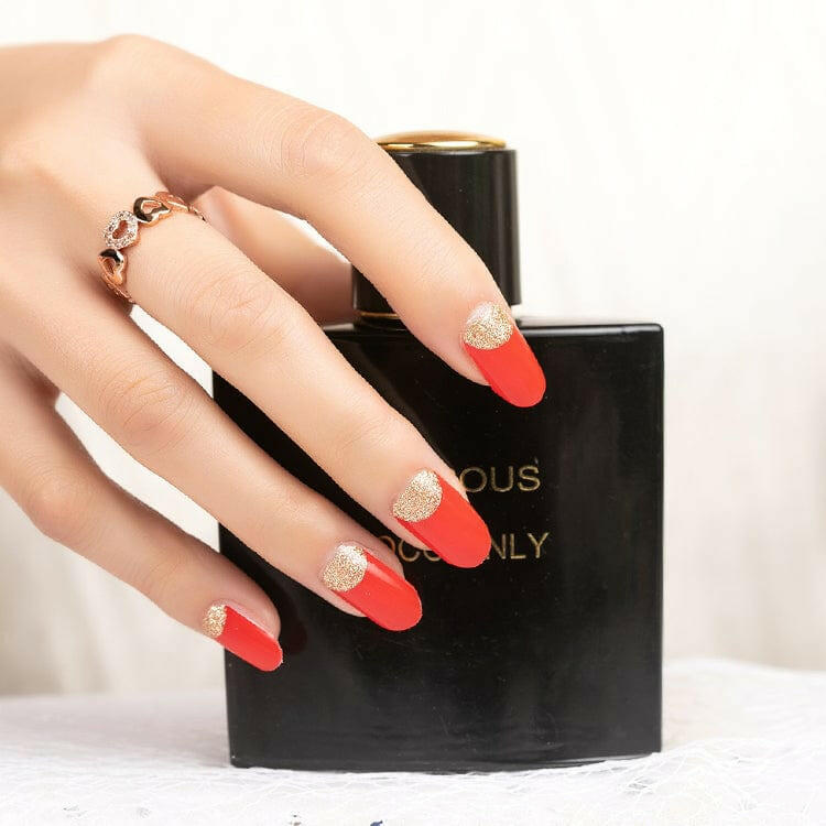 Coral-red nail wraps with glittery gold half-moon cuticle design, glossy finish