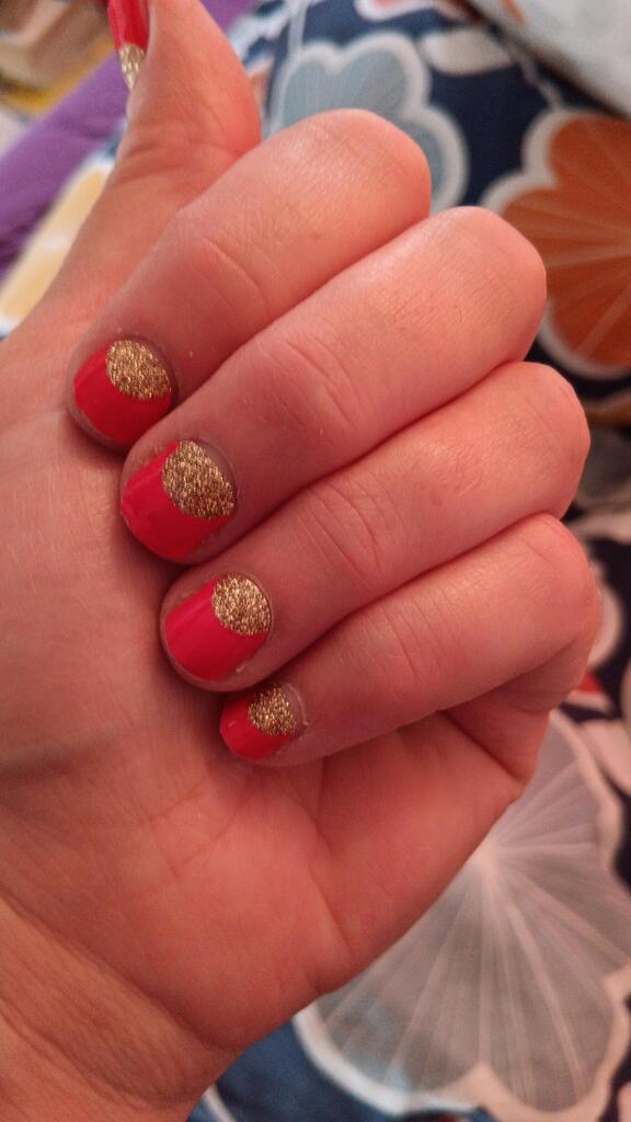 Red nail wraps with gold glitter accent tips displayed on fingers showing manicure results