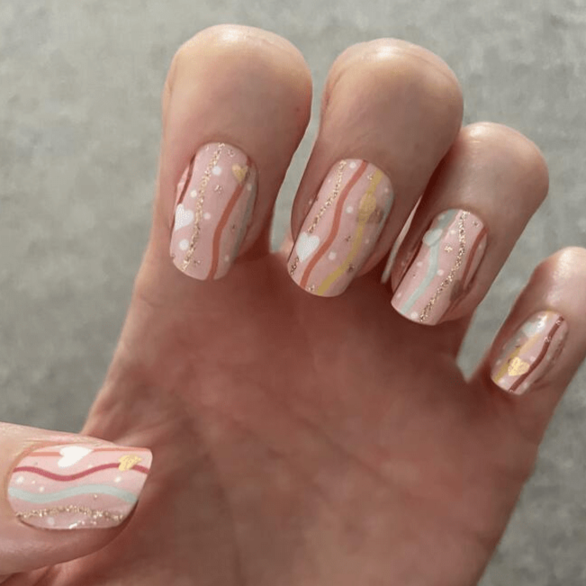 Marble effect nail wraps with gold foil accents on natural nails