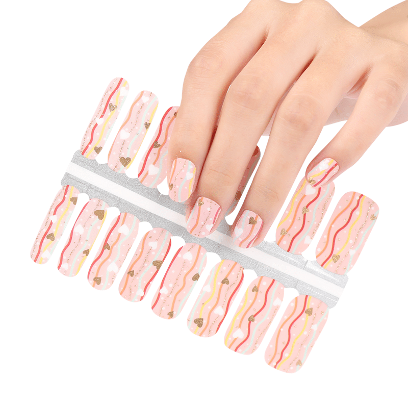 Hand selecting pink marble nail wraps with gold glitter streaks from sheet