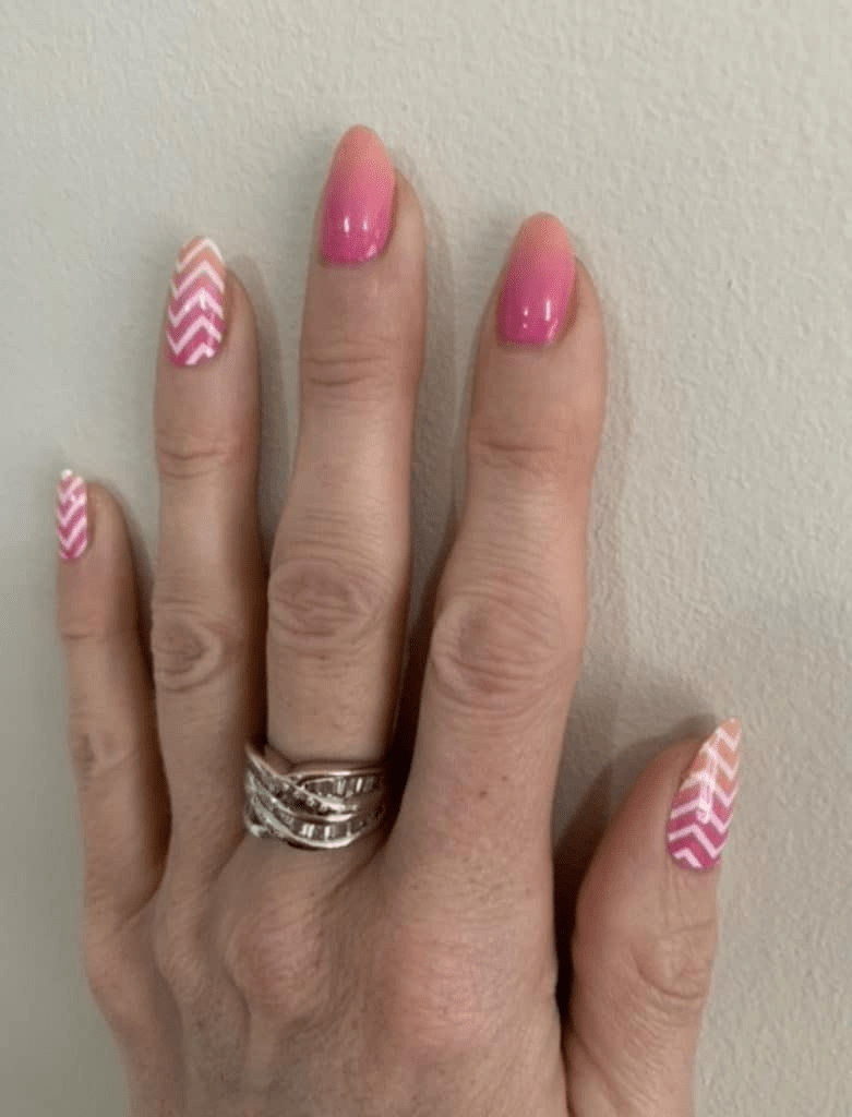 Pink glossy nail wraps with white chevron stripe pattern on accent nails