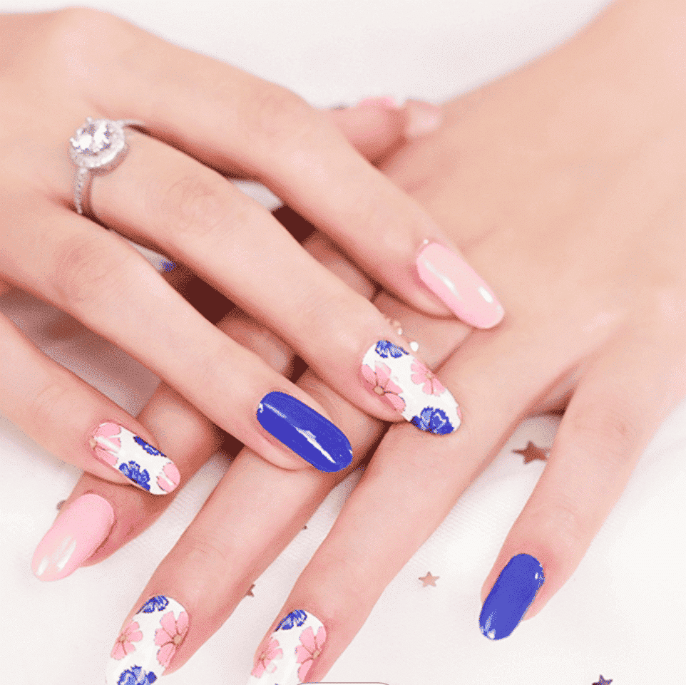 Pink and navy blue floral peony nail wraps on hand showing elegant botanical manicure design