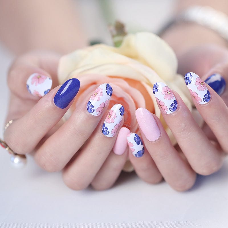 Floral nail wraps with pink peonies and navy accents displayed on hands with cream roses