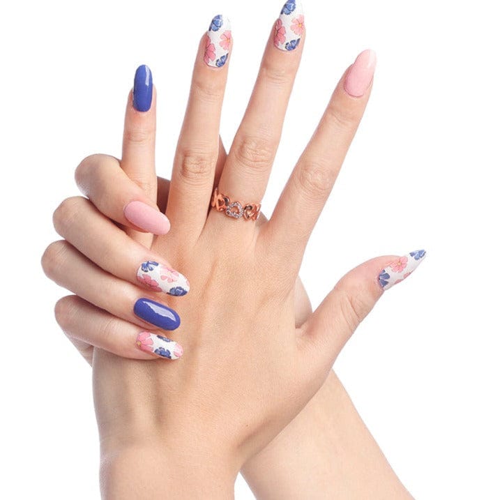 Hands wearing pink and blue peony floral nail wraps with navy accent nails