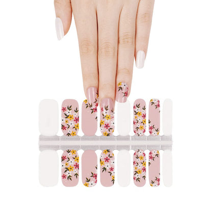 Pink nail wraps with pink and yellow floral print, alternating solid white accent nails