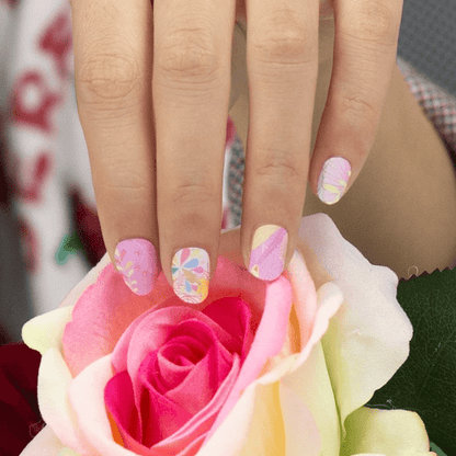 Feminine floral nail art wraps displayed on hand holding pink rose flower