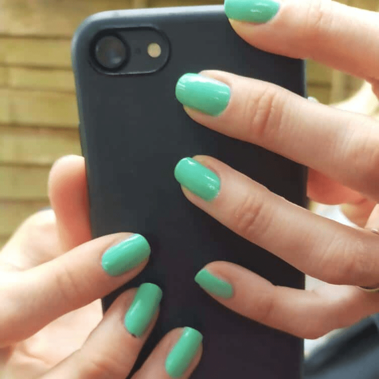 Glossy mint green nail wraps in a solid colour on short round nails