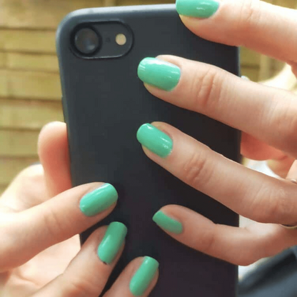 Glossy mint green nail wraps in a solid colour on short round nails