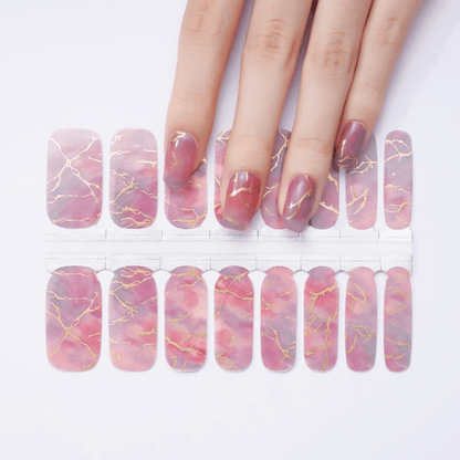 Non-UV nail wraps showing pink marble pattern with gold veins for at-home manicure